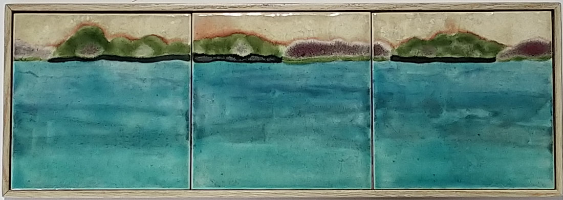 Three tiles framed depicting islands in the water